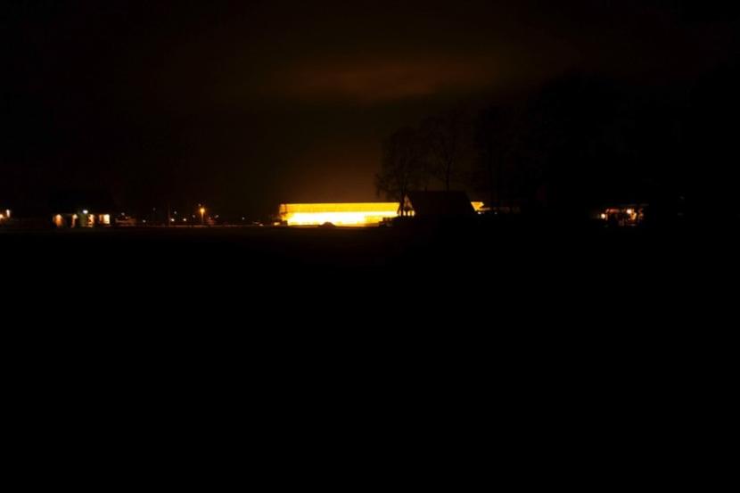 De gloed van de verlichting in een kas die de hele lucht ook verlicht.